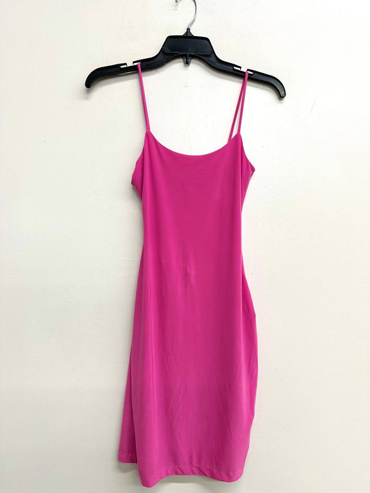 Pink slip dress on a hanger against a white background
