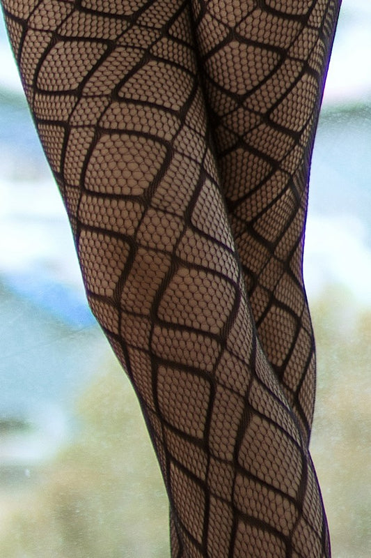 Black fishnet stockings with geometric pattern on a blurred natural background