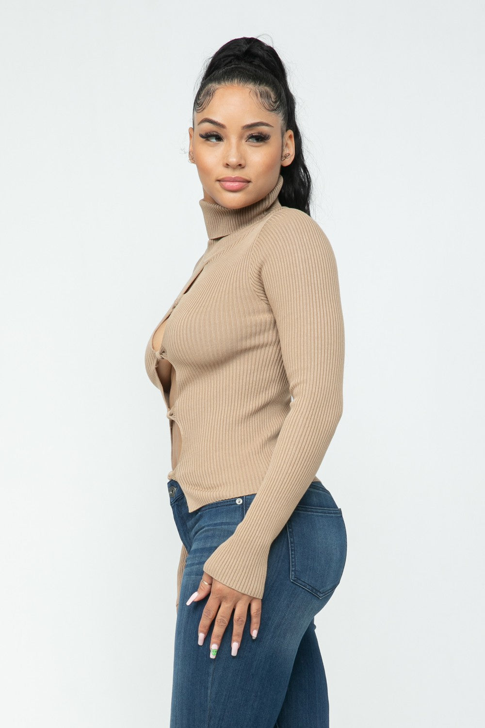 Woman wearing a milk coffee color ribbed sweater and blue jeans on a white background