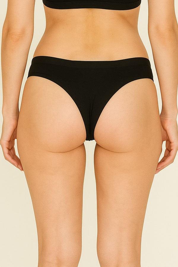 Person wearing black underwear on a beige background
