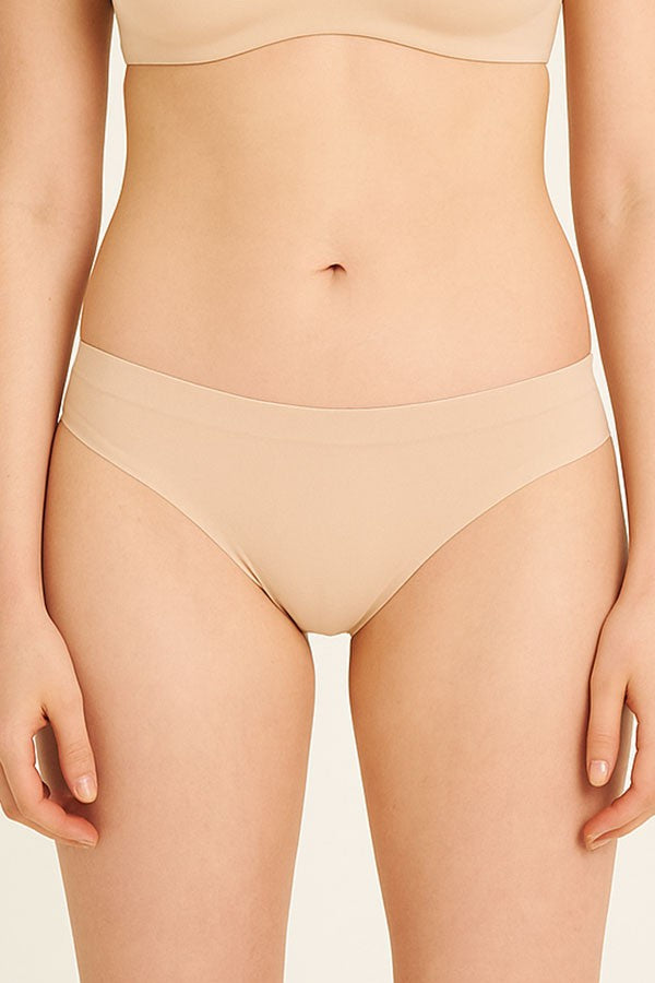 Beige underwear worn by a person on a plain background