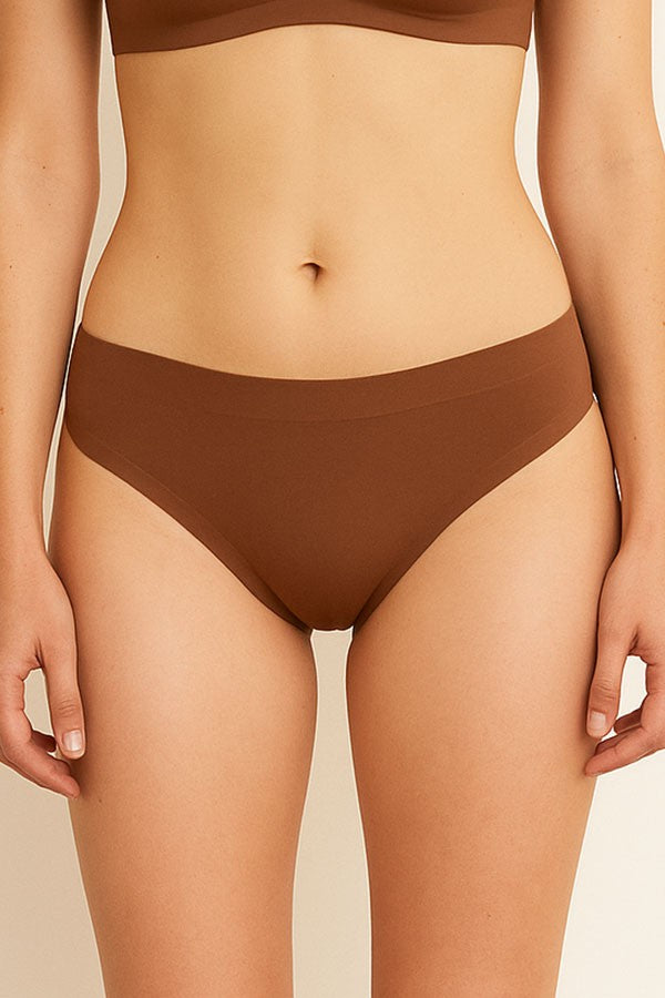 Brown bikini worn by a person on a beige background