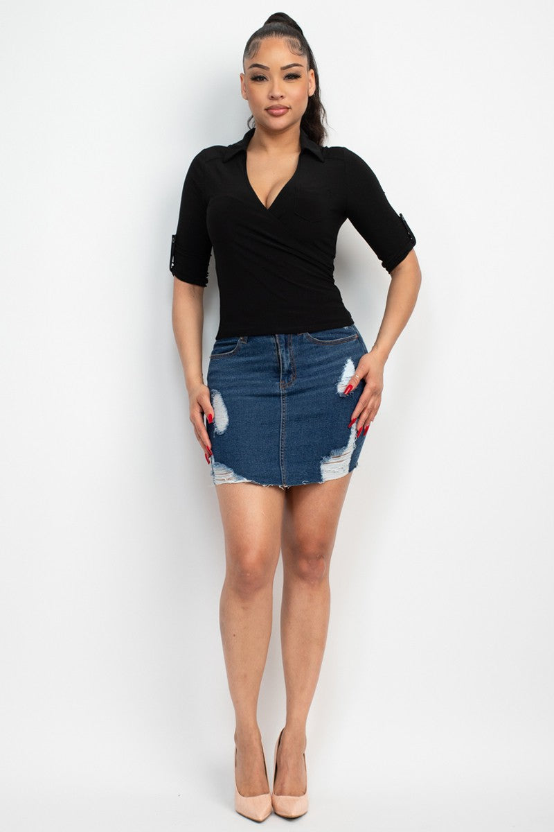 Woman wearing a black top and denim skirt on a white background