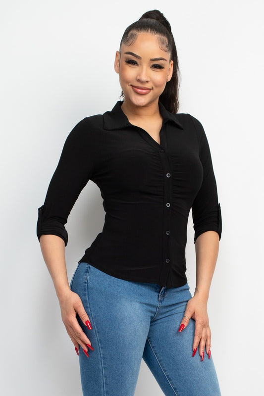 Woman wearing a black shirt and blue jeans against a white background