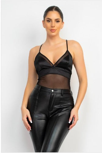 Woman wearing a black leather bodysuit on a white background