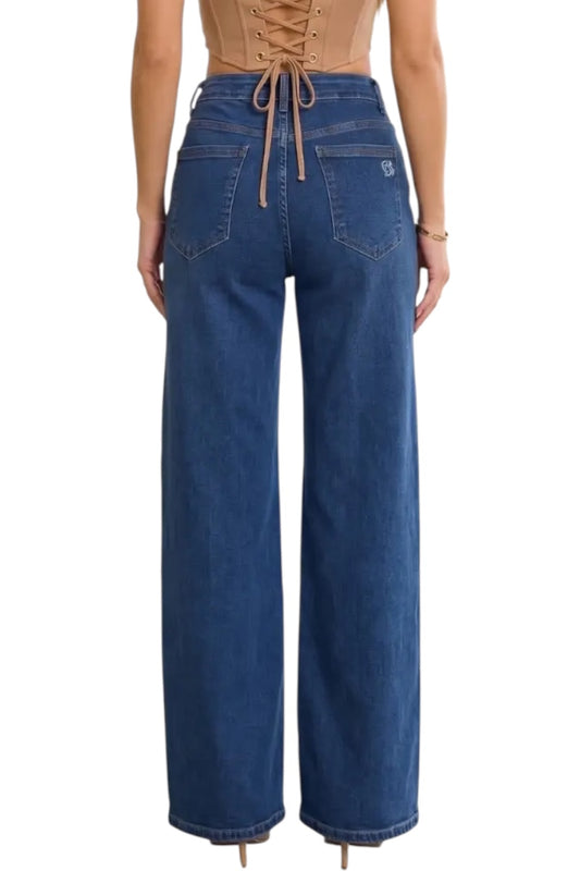 A model shown from the back wearing high-waisted, wide-leg blue jeans with a drawstring waistband and a small silver logo on the back pocket.