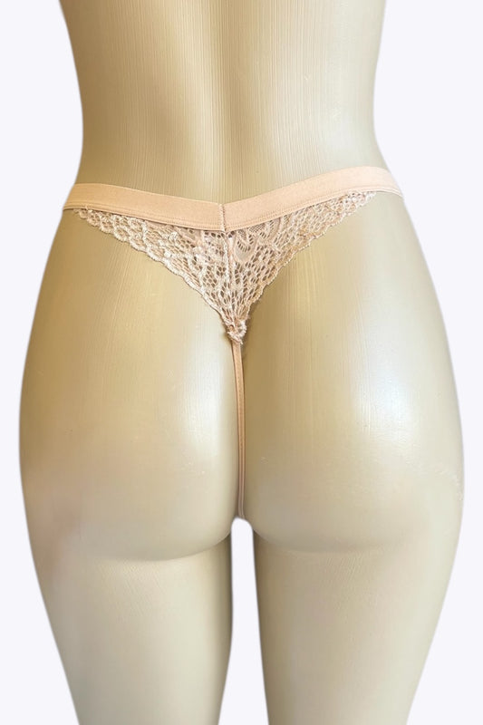 Beige lace thong on a mannequin against a white background