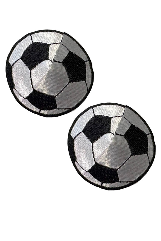 Two black and white checkered round soccer ball pasties on a white background