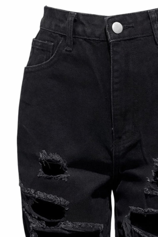 Close-up of black distressed jeans with a white background