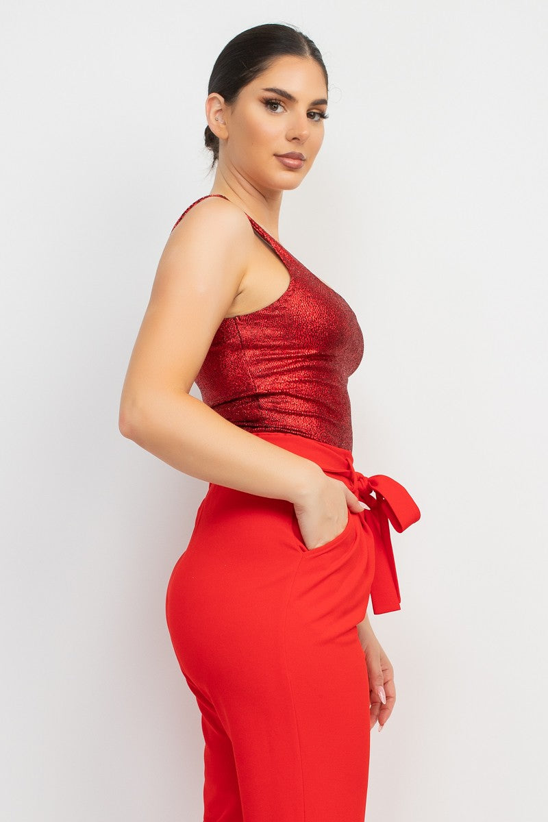 Woman wearing a red top and pants with a white background