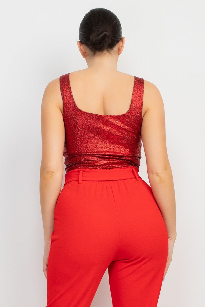 Person wearing a red metallic top and red pants on a white background