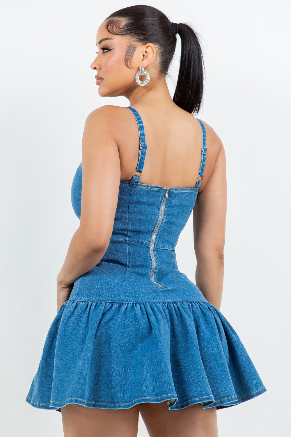 Woman wearing a blue denim dress against a white background