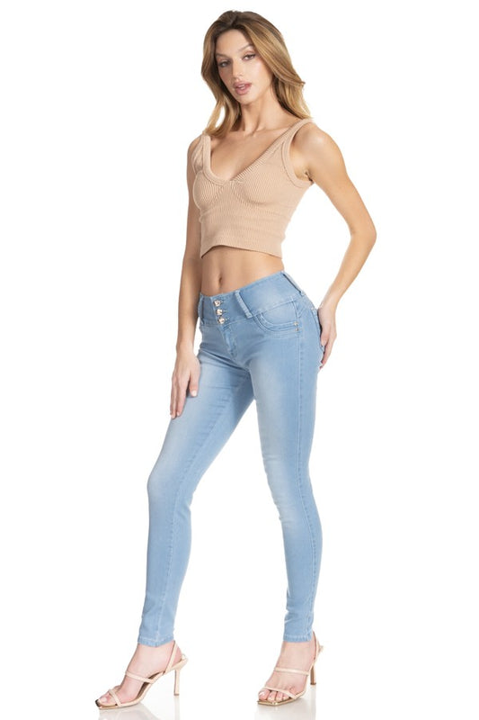 Woman wearing light blue jeans and a beige top on a white background