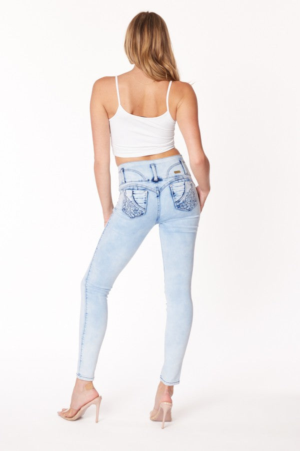 Woman wearing light blue jeans with decorative stitching on a white background