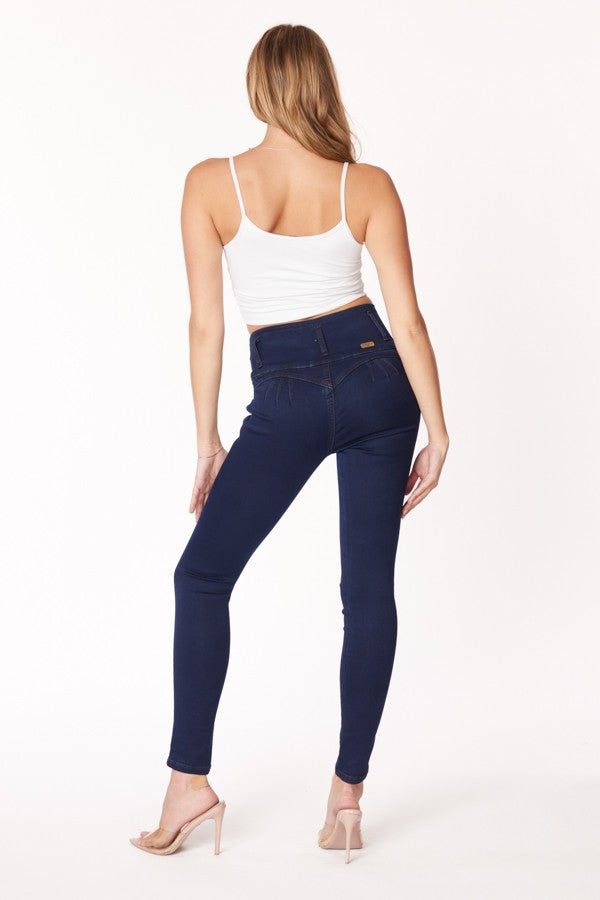 Woman wearing navy blue jeans and a white top on a white background