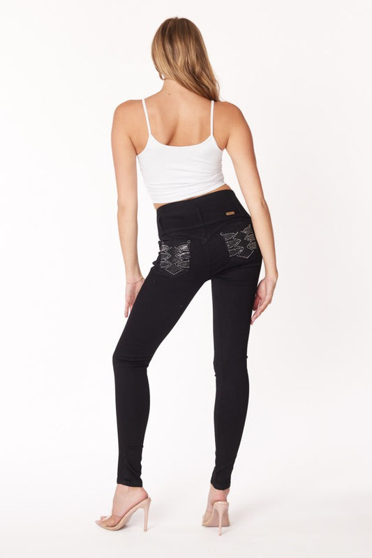 Woman wearing black leggings with studded details on a white background