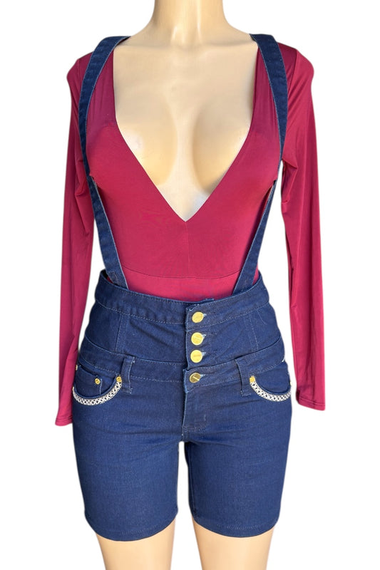 Mannequin wearing a red top and blue denim overalls with yellow buttons on a white background