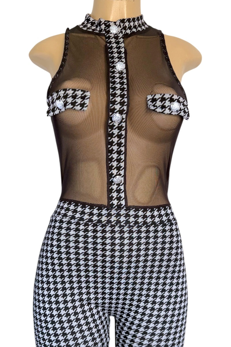 Mannequin wearing a houndstooth patterned outfit with sheer top and black and white checkered pants.
