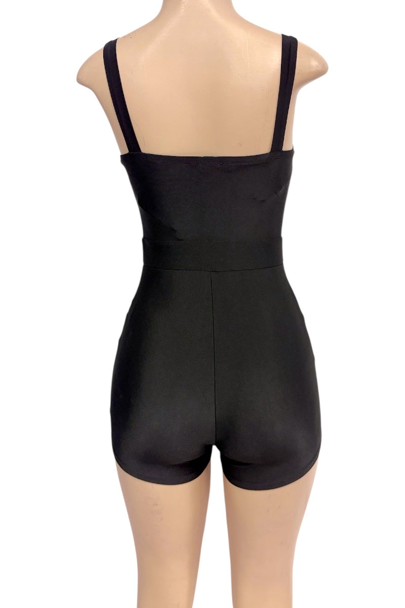 Black romper with shoulder straps and mid-thigh shorts, displayed on a mannequin from the back against a white background.