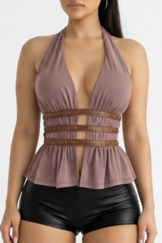Woman wearing a brown peplum top with brown belt and black shorts on a white background