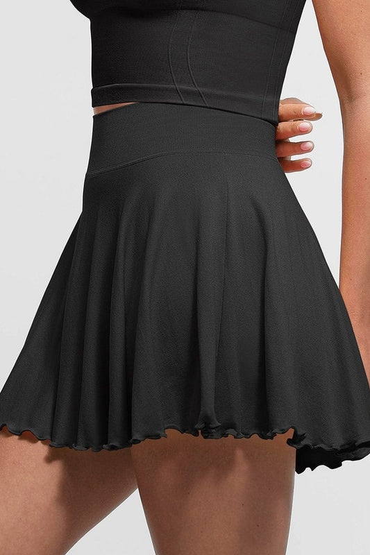 Black skirt worn by a person on a plain background