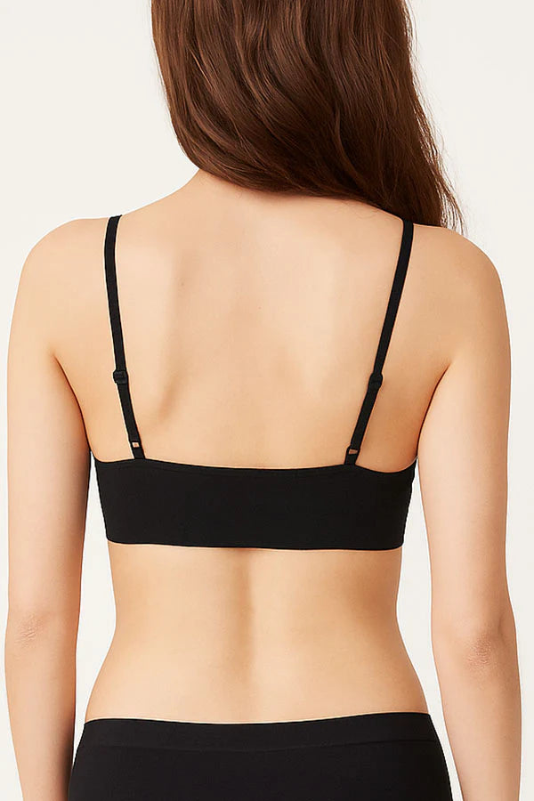 Black bra worn by a person on a plain background