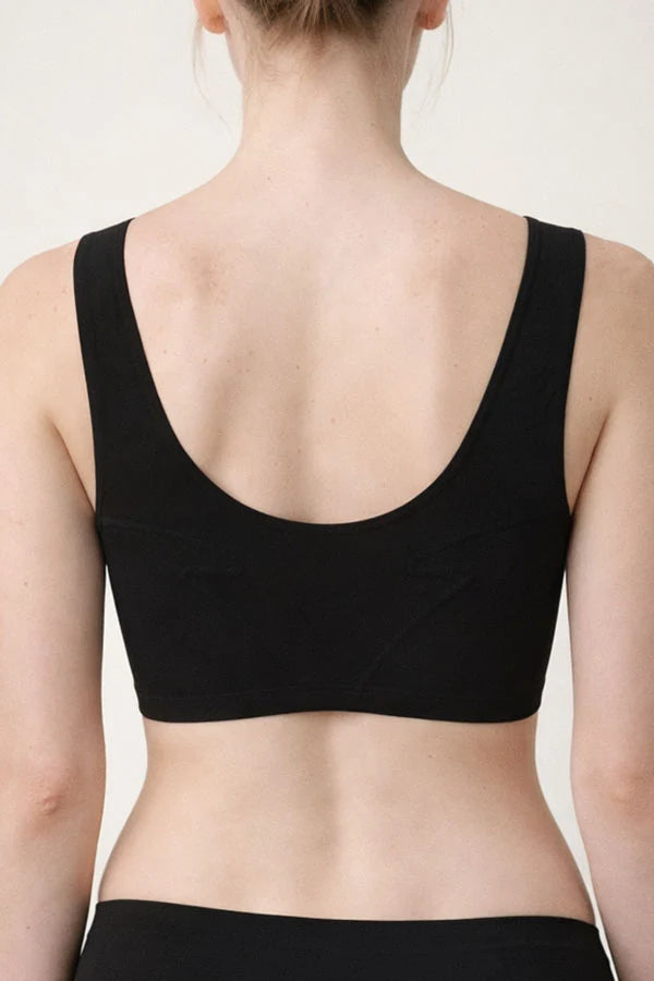 Rear view of a woman wearing a black scoop-neck bra or bralette against a plain light background.