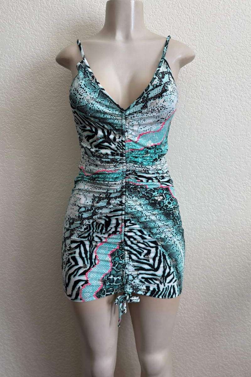 Mannequin wearing a patterned dress with zebra and abstract designs on a plain background