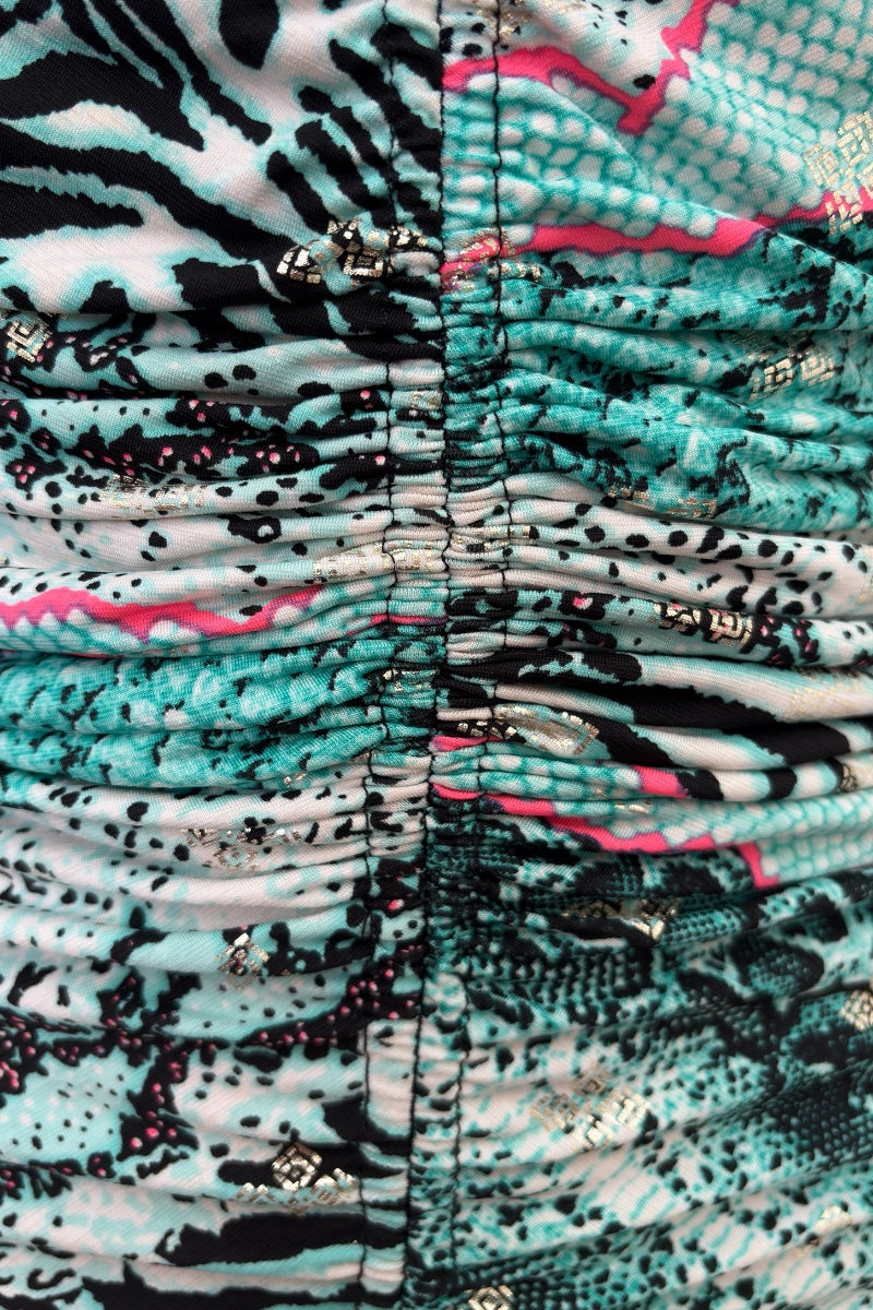 Close-up of a patterned fabric with teal, black, and pink colors.