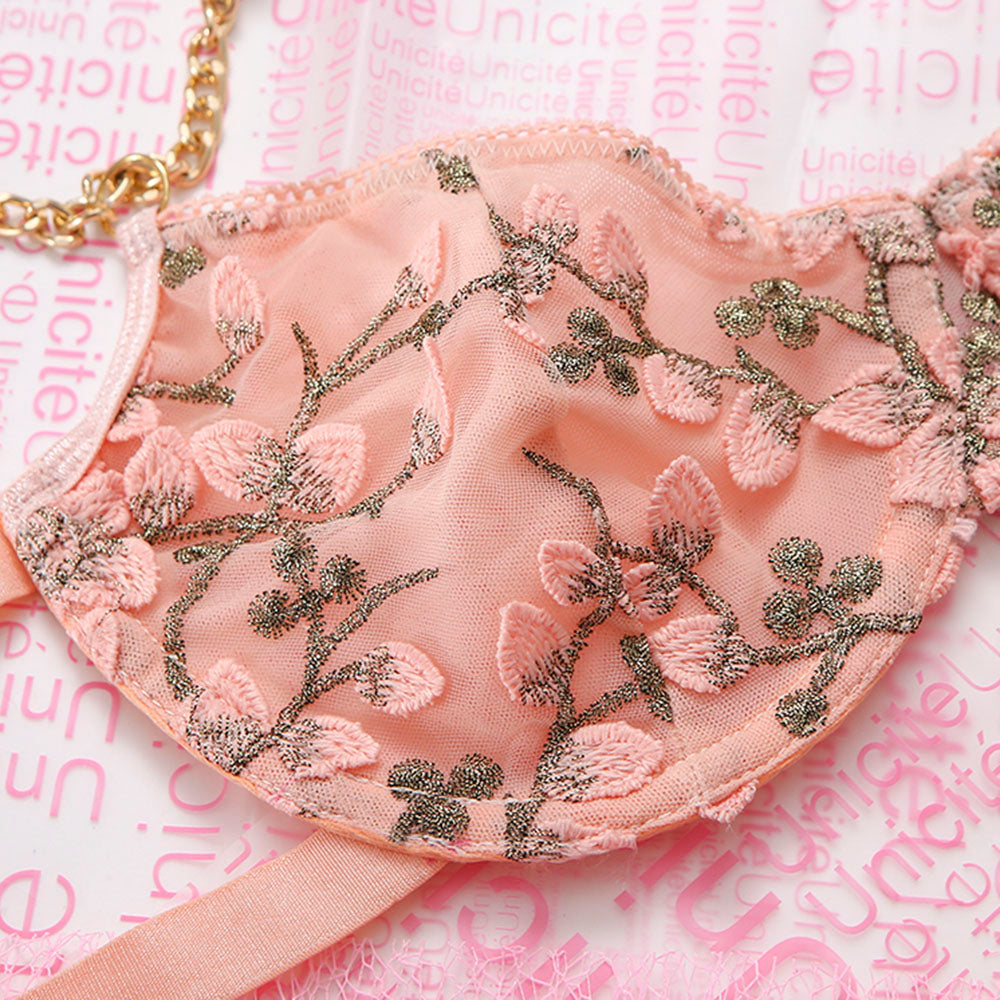 Pink embroidered bra with floral patterns on a pink background