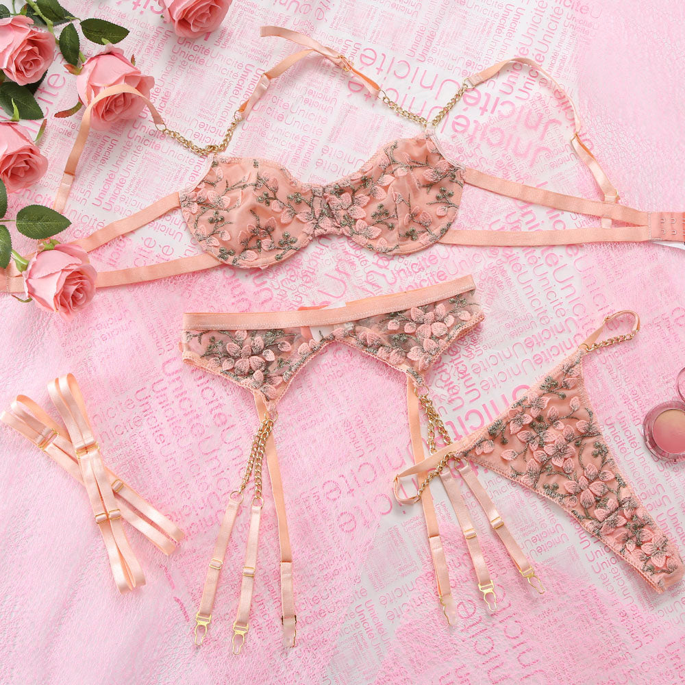Floral lingerie set on a pink textured fabric background with roses.