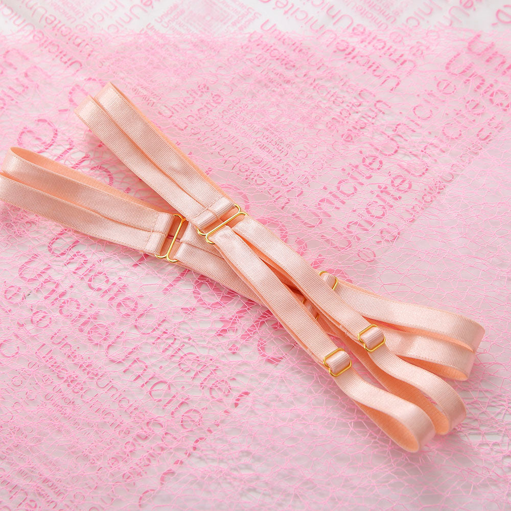 Set of leg garters with gold clasps on a pink background with text