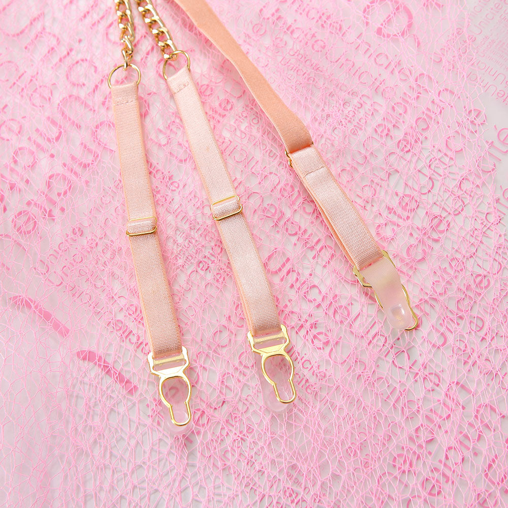 Three pink garters with gold hardware on a pink textured background