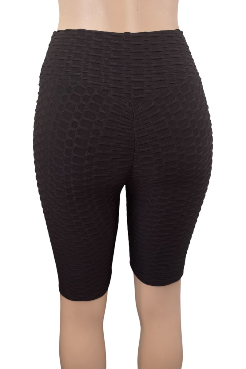 Black textured shorts worn by a person on a white background
