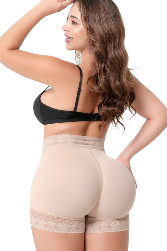 Woman wearing a black bra and beige shapewear on a white background
