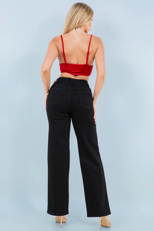 Woman wearing a red top and black pants against a light blue background