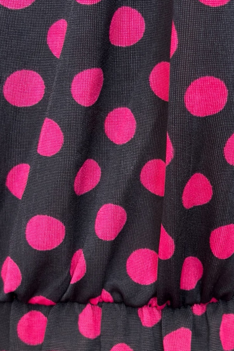 Close-up of black fabric with pink polka dots