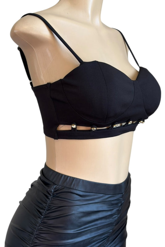 Black crop top with thin straps and gold accents on a mannequin against a white background