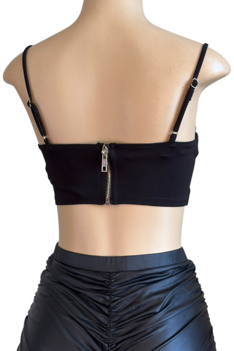 Black crop top with thin straps and zipper on a mannequin against a white background