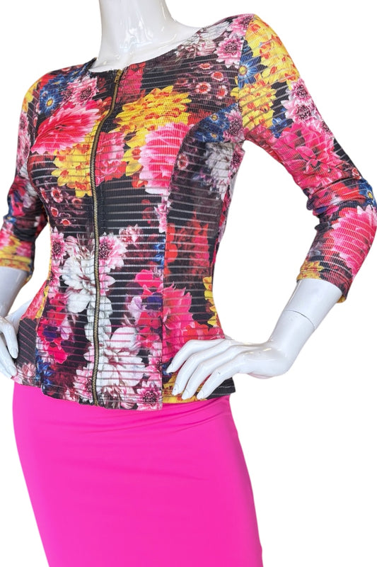 Mannequin wearing a colorful floral-patterned top and pink skirt on a white background
