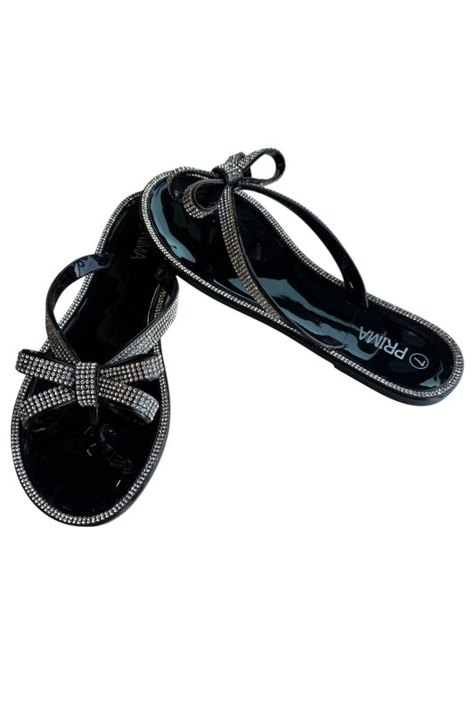 Black sandals with bow design on a white background