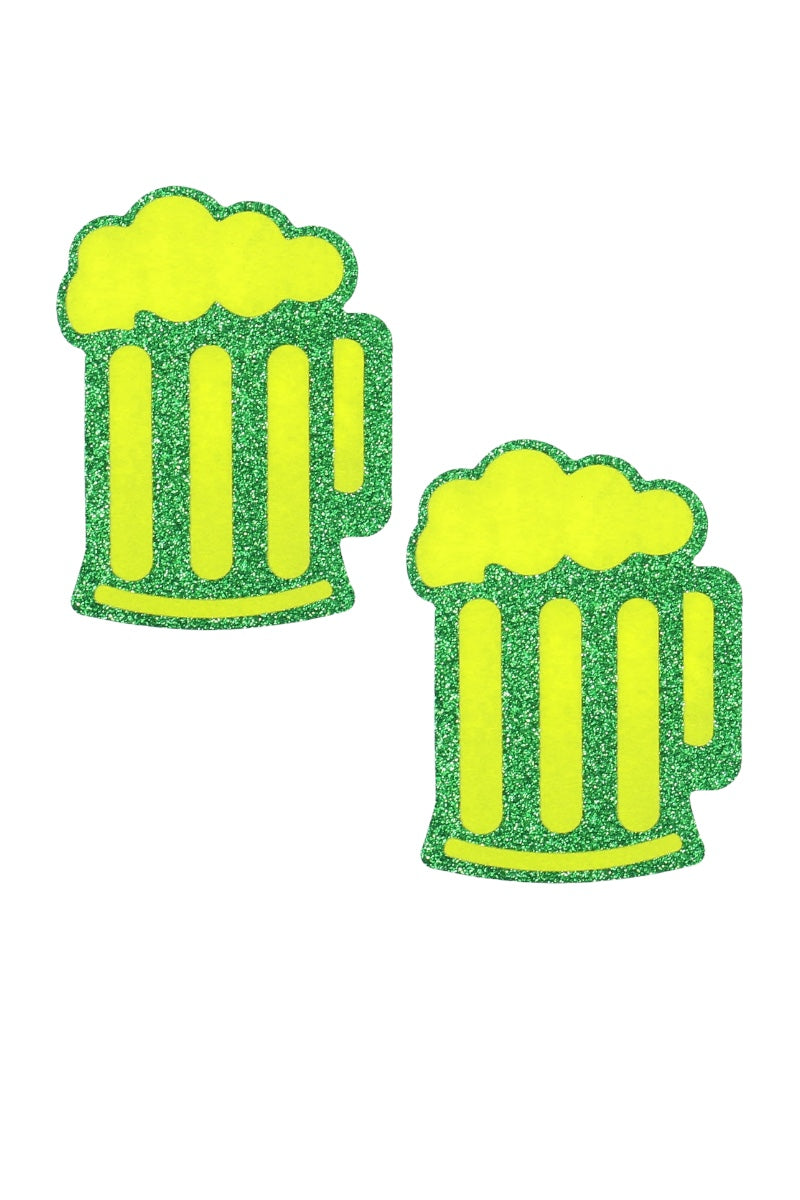 Two green glittery beer mug-shaped pasties on a white background