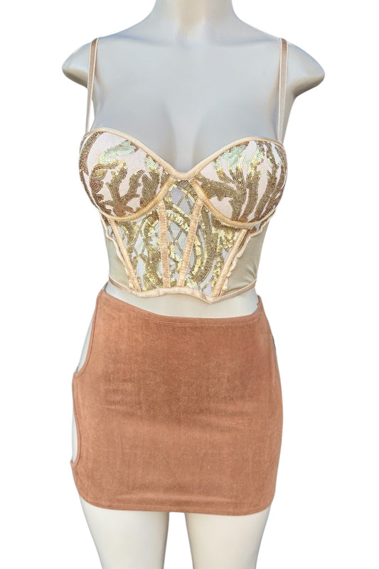 Mannequin wearing a golden sequined top and brown skirt on a white background
