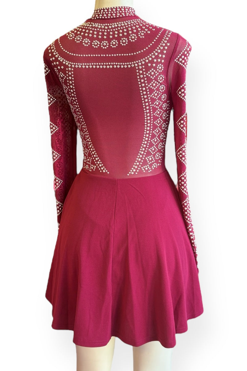 Burgundy dress with intricate embellishments on a white background