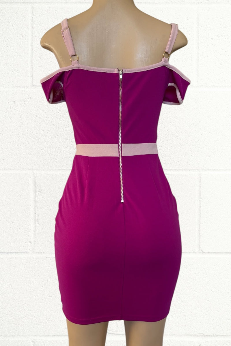 pink dress with beige accents on a mannequin against a white tiled wall.