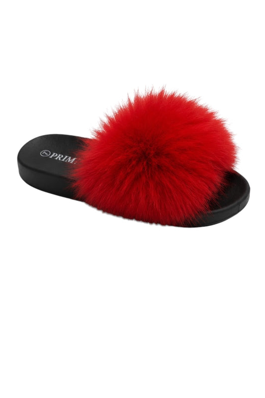 Black slide sandal with a large red faux fur pom-pom on a white background