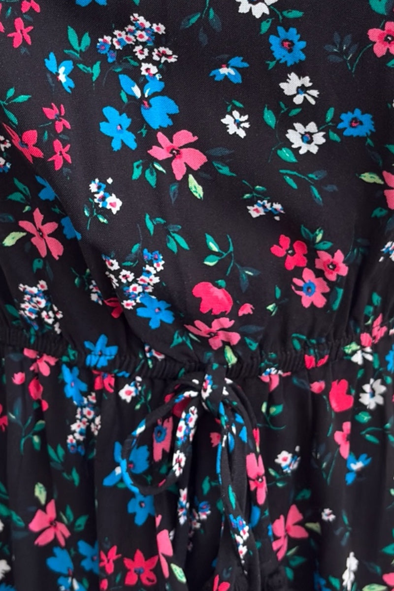 Floral patterned fabric with pink, blue, and white flowers on a black background