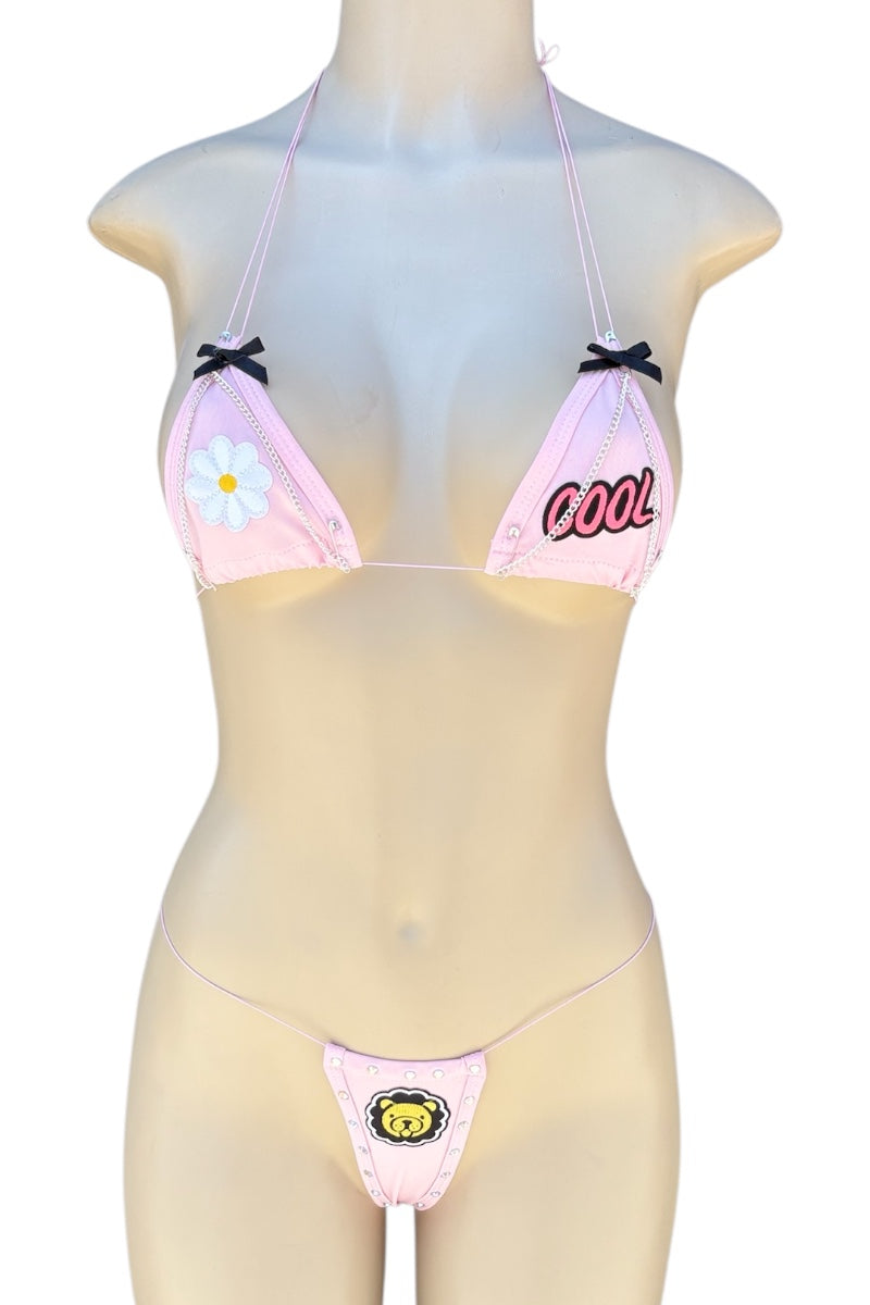 Mannequin wearing a pink bikini with floral and text design on a white background