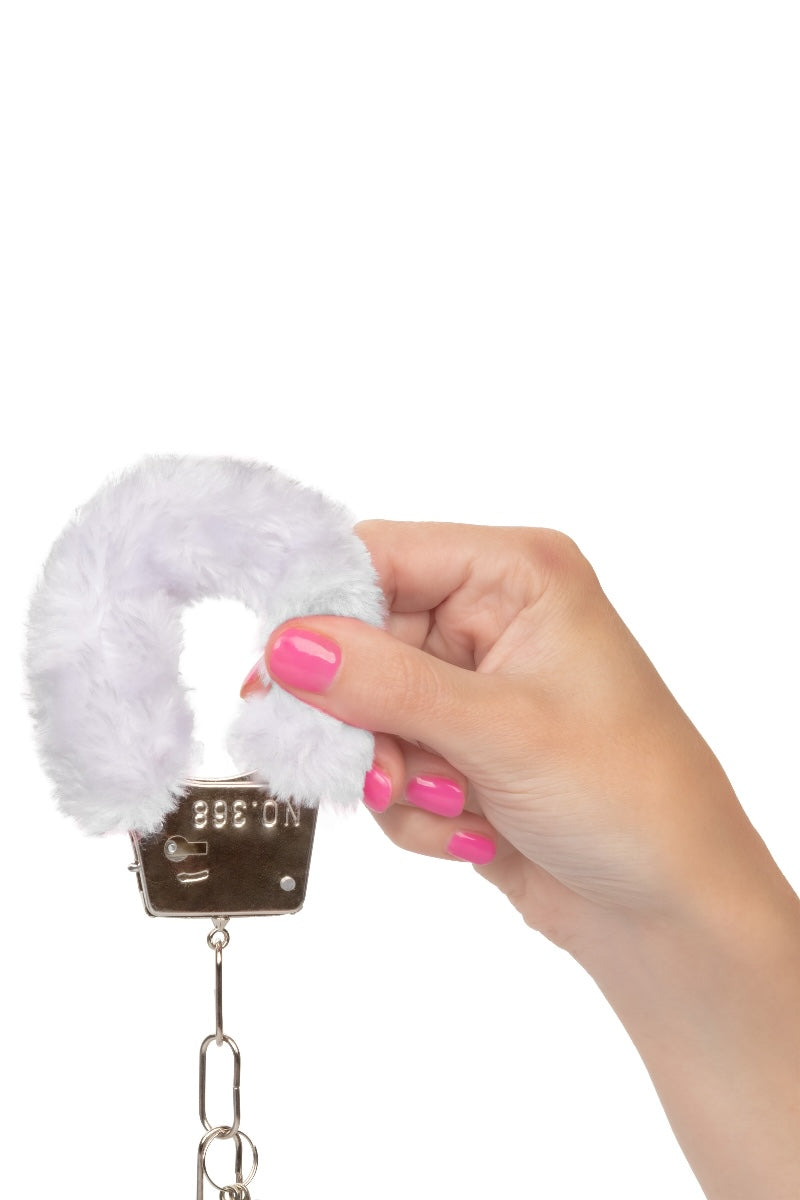 Hand holding a white handcuffs with a metal clasp on a white background