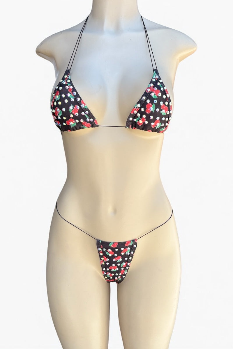 Bikini set with cherry pattern on a mannequin against a white background